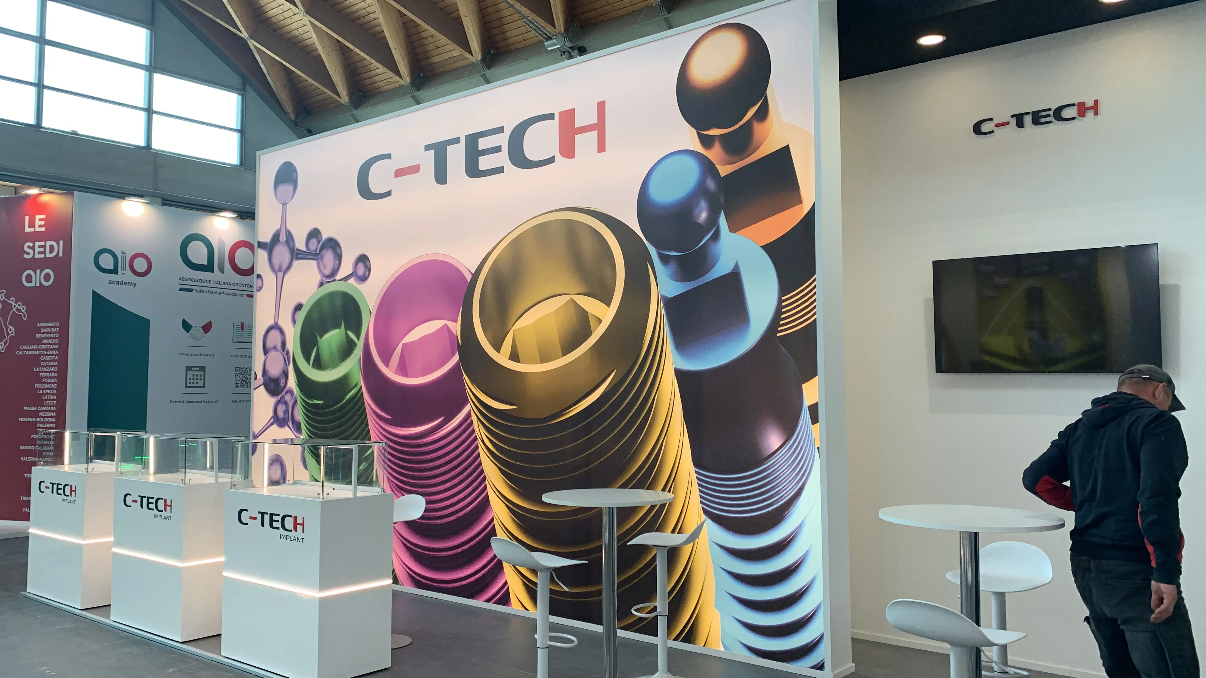 Stand C-Tech Implant a Expodental, parete grafica con render di impianti dentali e totem prodotto