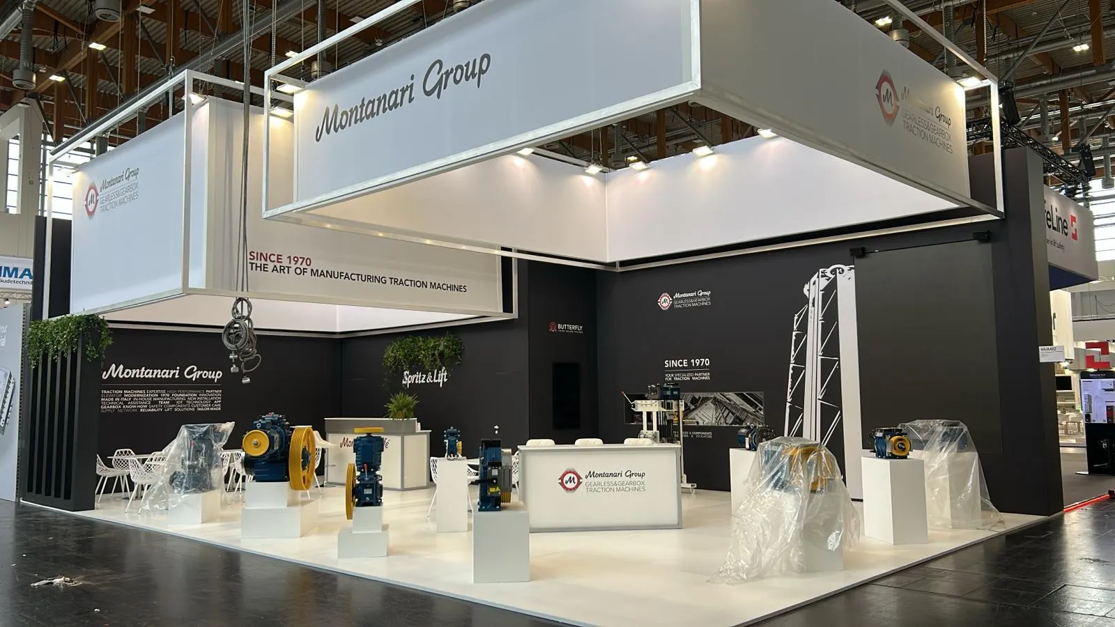 Stand Montanari Group realizzato in fiera, identico al render, con macchinari esposti su basamenti bianchi