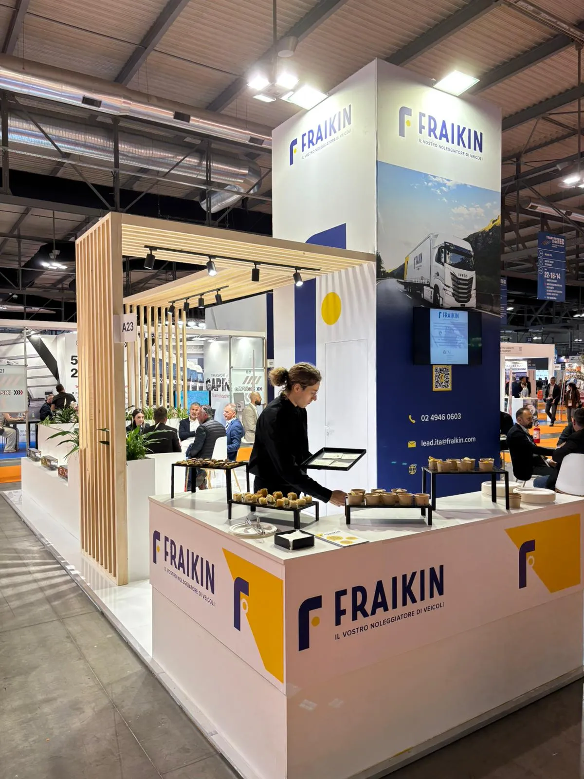 Stand Fraikin a Transpotec, area reception con servizio di catering e insegna aziendale